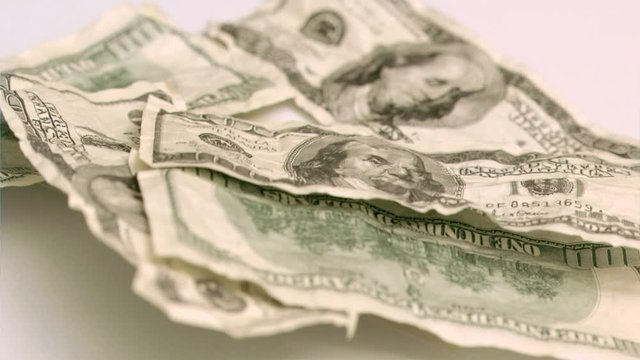 Wind blowing in super slow motion to show one hundred dollar banknote