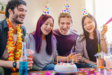 Group of happy friends celebrating birthday at home