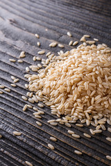 Obraz premium raw brown rice on dark rustic wooden background