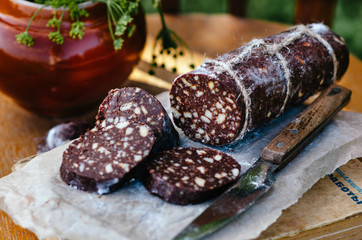 Dessert of cookies, Sweet chocolate sausage (confectionery wurst) on white plate, close up. Rustic style.