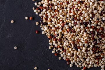 mix of quinoa grains on a dark stone background