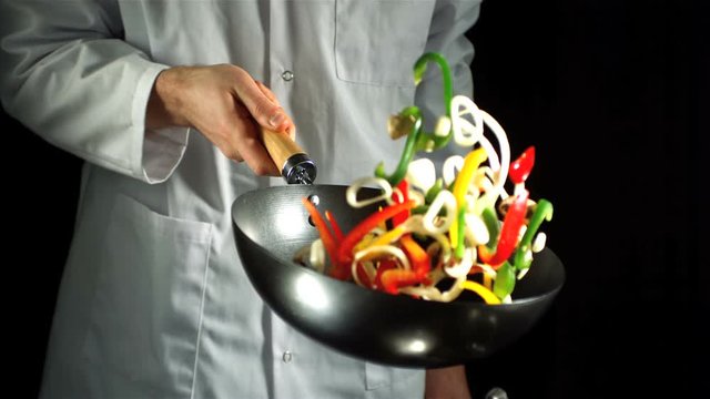 Chef tossing vegetable stir fry in wok