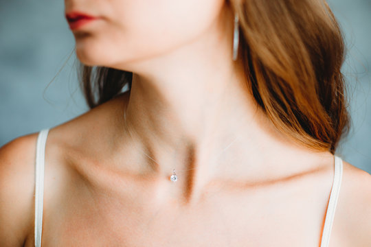 Beautiful slim neck of a young caucasian girl with jewelry. Shallow focus. Bokeh