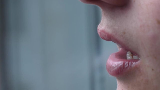 young woman exhales cloud of smoke from cigarrette slow motion