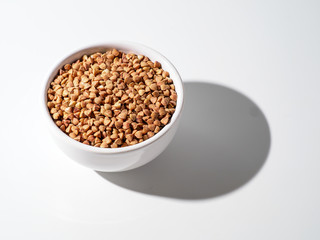 Plate with buckwheat isolated on white background.