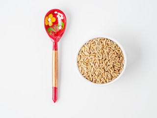 Spelt in the bowl isolated on white background.