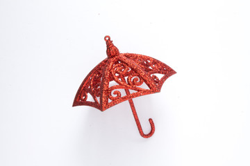 red toy umbrella, toy decorative decoration for Christmas lies on a white background