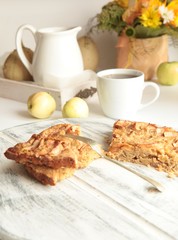 Freshly baked apple pie with apples in the background.
