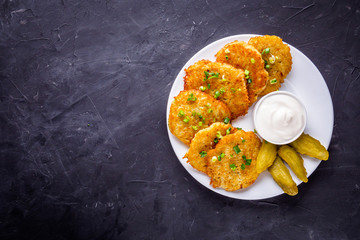 Delicious crispy potato pancakes on dark stone background