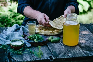 Foto op Canvas Johnny cake with cheese with greens. Man eating cakes on a table in nature. © sokorevaphoto
