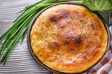 freshly baked cabbage pie on rustic wooden background