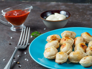 Russian pelmeni on the blue plate.