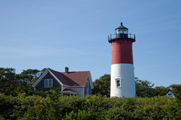 Fototapeta na wymiar Nauset Lighthouse on the east coast of the United States stands tall in red and white as a beacon of safety
