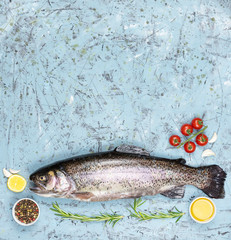 raw fish, trouts dark background with vegetables and spices
