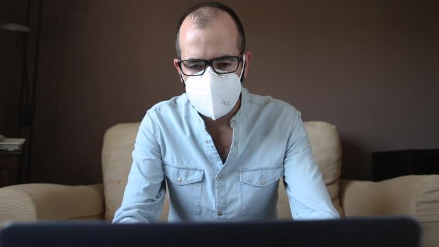 Sick businessman in white mask working remotely from home. Telecommuting in the new normality concept