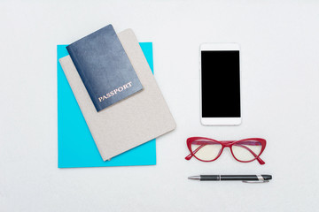 Passport, blue notebook, pen, red women's glasses and phone, white background, top view, place to record