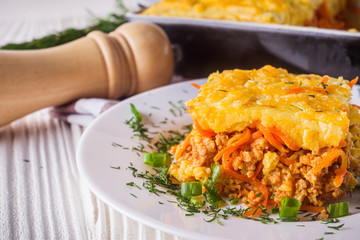 Delicious potato casserole with meat and cheese on a white wooden background