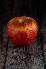 Red Wilted rotten apple on a wooden surface background