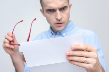 Amazed guy reads the letter, close up