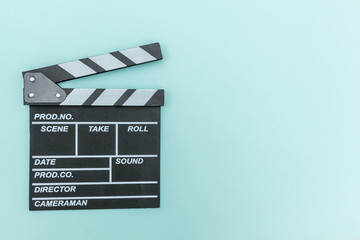 Fototapeta na wymiar Filmmaker profession. Classic director empty film making clapperboard or movie slate isolated on blue background. Video production film cinema industry concept. Flat lay top view copy space mock up.