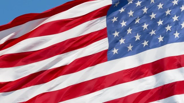 American flag waving in the wind on blue sky, US flag slow motion close-up, United States of America national flag, 4k