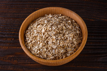 raw oatmeal on a wooden rustic background