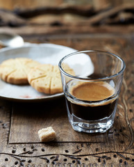 Coffee in glass cup on rustic wooden background. Close up.