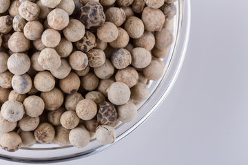 white peppers in glass bowl on white background