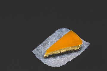 Piece of cheesecake with sea buckthorn and cake