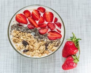 Healthy breakfast superfood smoothie bowl topped with granola and strawberry. close up. delicious berry smoothie bowl. vegan raw food. Selective focus.