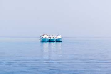 Boats yachting in the blue sea, ships in calm open ocean