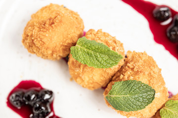 croquettes round fried cottage cheese sweet dessert balls with syrup and cherries on a white plate
