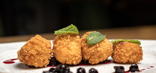 croquettes round fried cottage cheese sweet dessert balls with syrup and cherries on a white plate