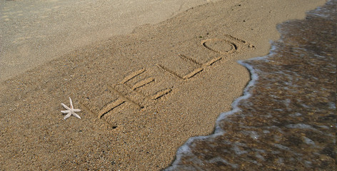 Mensagem em inglês escrita na areia de uma praia junto ao mar com pequena onda em movimento e uma estrela do mar, Hello - obrazy, fototapety, plakaty