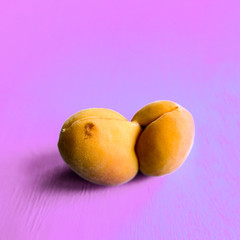 An ugly organic fruit-an oddly shaped yellow apricot on a lilac background. Buying imperfect products is a way to deal with food waste. Copy space