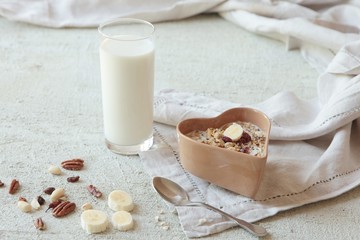 bowl of homemade muesli with nuts, berries, dried fruits, glass of milk and honey. healthy...