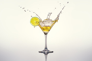 cocktail glass with lime and splashes