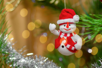 Christmas toy snowman in red outfit smiles and waves his hand