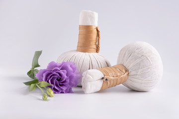 Fototapeta na wymiar Cosmetic set for massage with bags of herbs and purple flower on white background