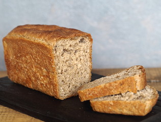 Freshly baked diet rye bread on a wooden table with a gray background.