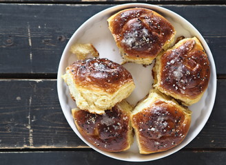 Homemade cake.The view on top of buns ,sprinkle with sesame seeds and sugar syrup on the dark table.