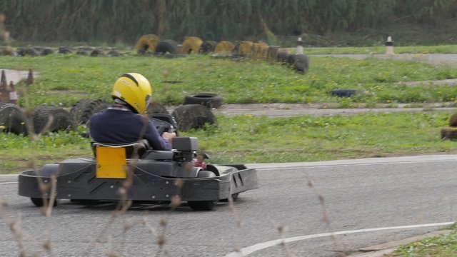 People driving karts on a kart track slow motion
