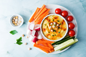 Hummus appetizer with carrot, radish, tomato and cucumber