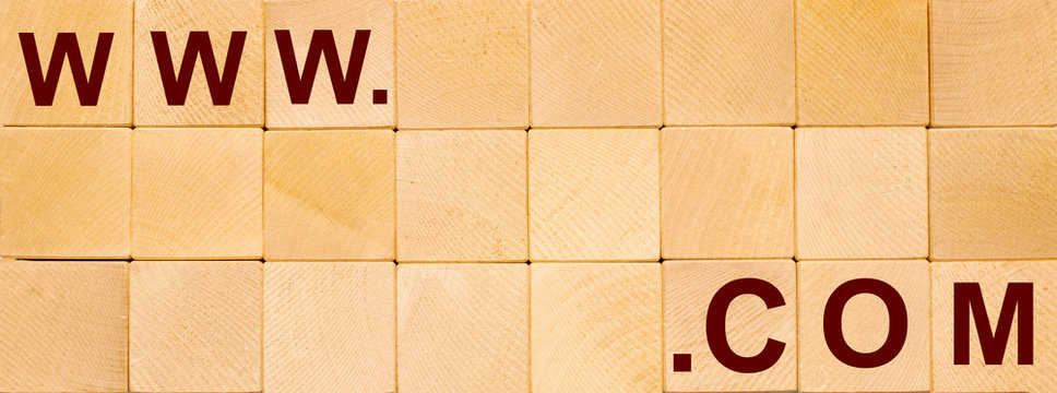 WWW and COM lettering on wooden cubes on a wooden background.Domain concept.