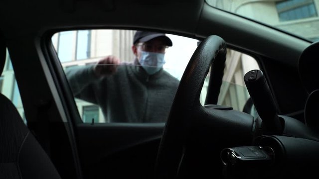 Burglar stealing key from the car