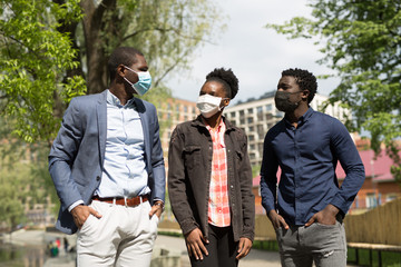 team of young african people in summer on a walk in the park in protective face masks