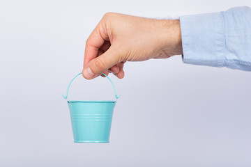 Male hand holds small buckets pails on white background. © somemeans