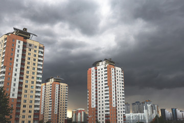 Houses on a background of gloomy stormy sky. Concept of crisis and problems.