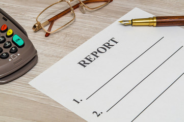 The report form on the office desk with glasses and pen