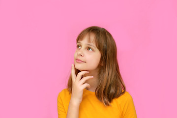 Child on a pink background. The girl in the orange t-shirt came up with something interesting.